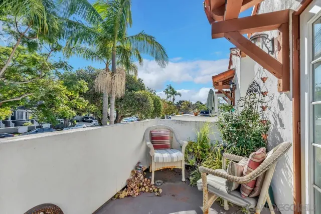 a roof deck with table and chairs potted plants
