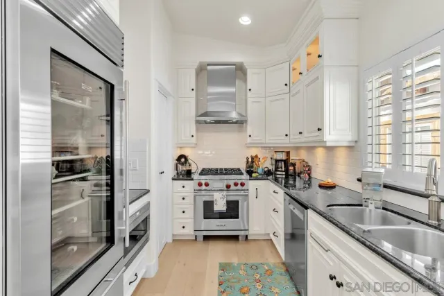 a kitchen with stainless steel appliances a stove a sink and a refrigerator