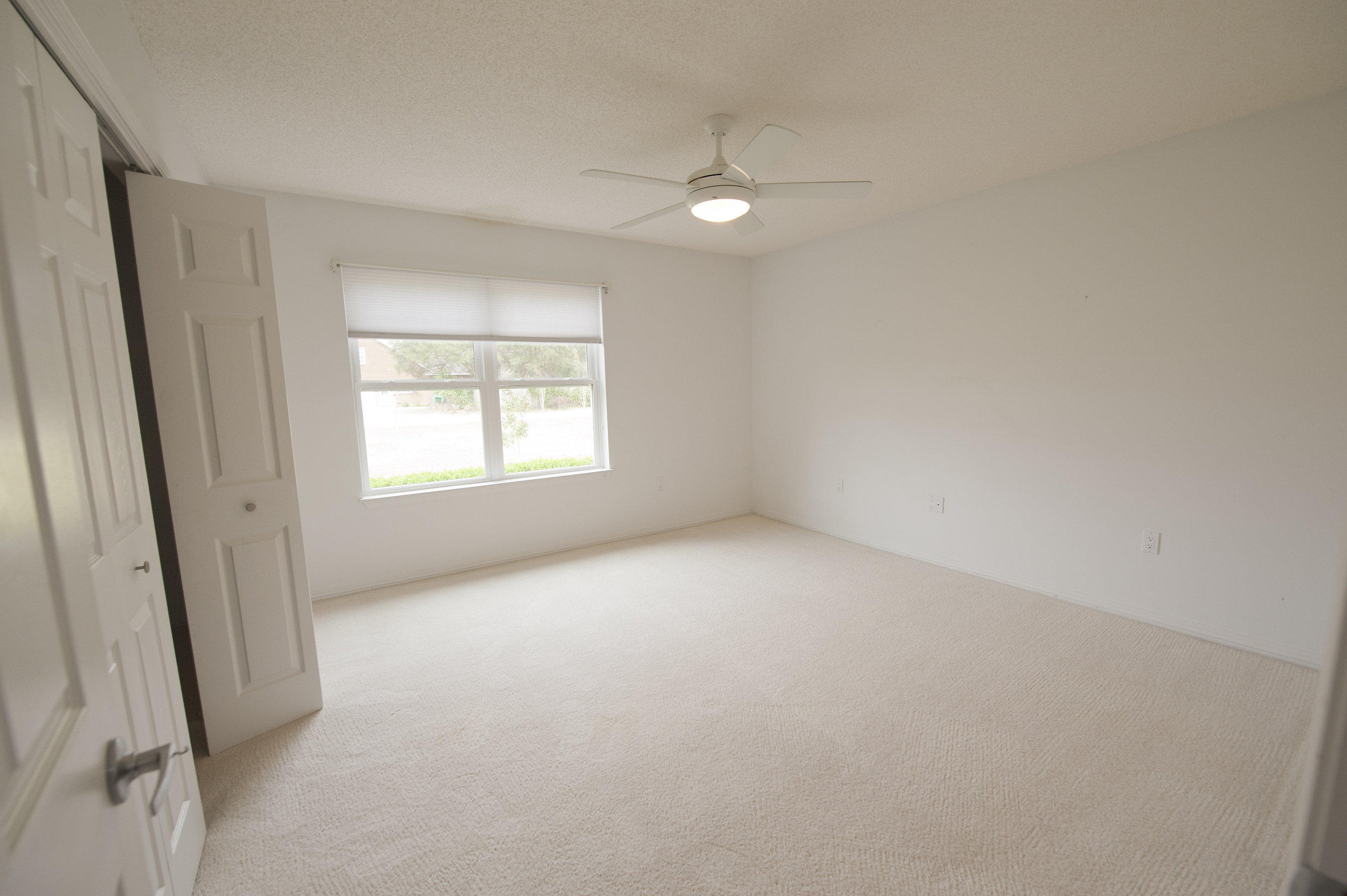 2557 Crescent Road Navarre, FL 32566 - Photo 22 of 48 an empty room with windows and fan