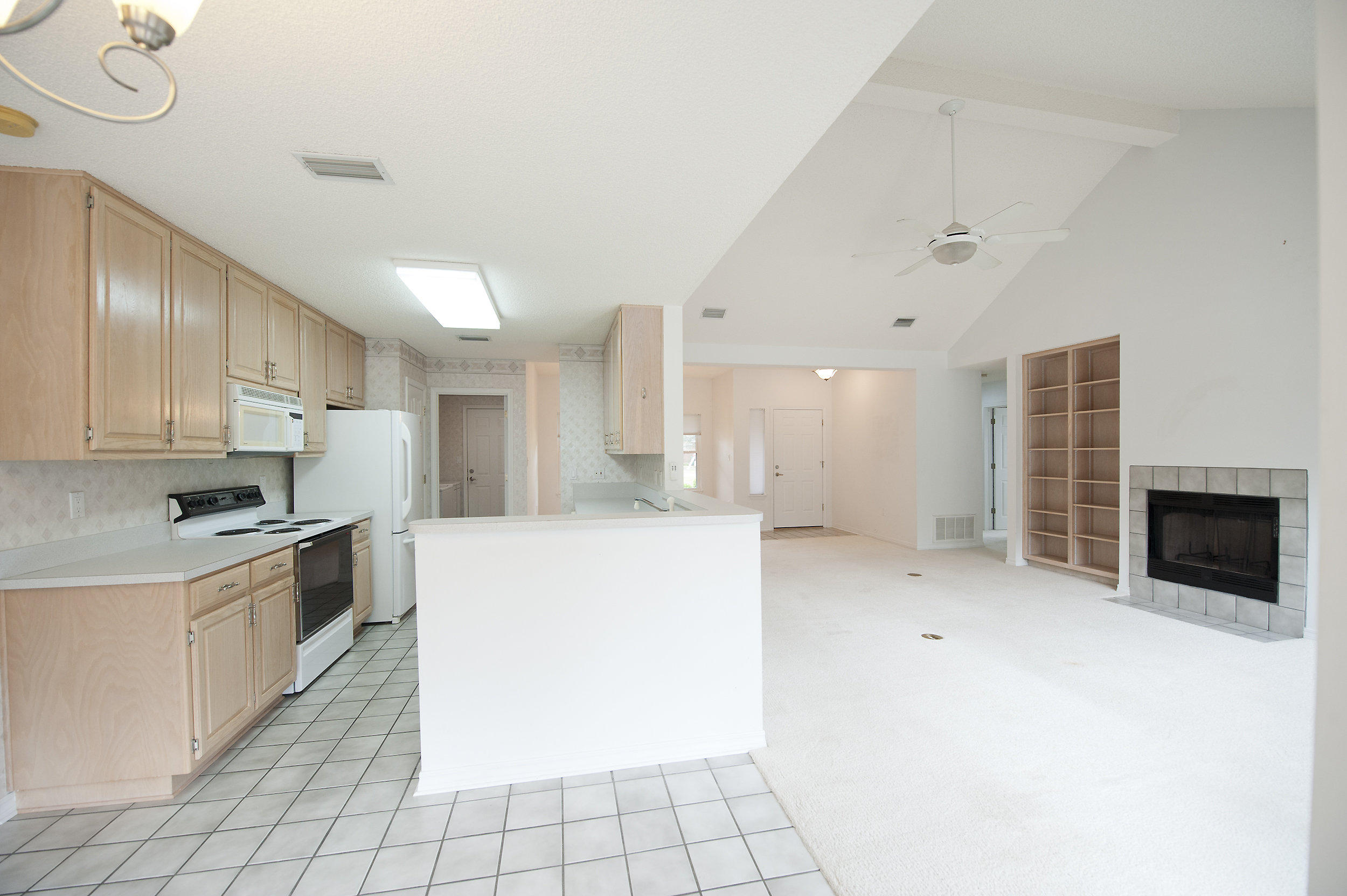 2557 Crescent Road Navarre, FL 32566 - Photo 29 of 48 a large kitchen with granite countertop a stove a sink dishwasher and a refrigerator with wooden floor