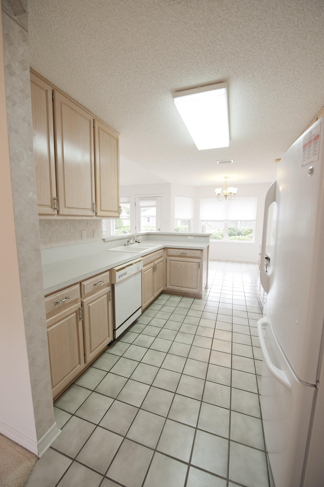 2557 Crescent Road Navarre, FL 32566 - Photo 31 of 48 a large white kitchen with a sink and dishwasher a refrigerator with white cabinets