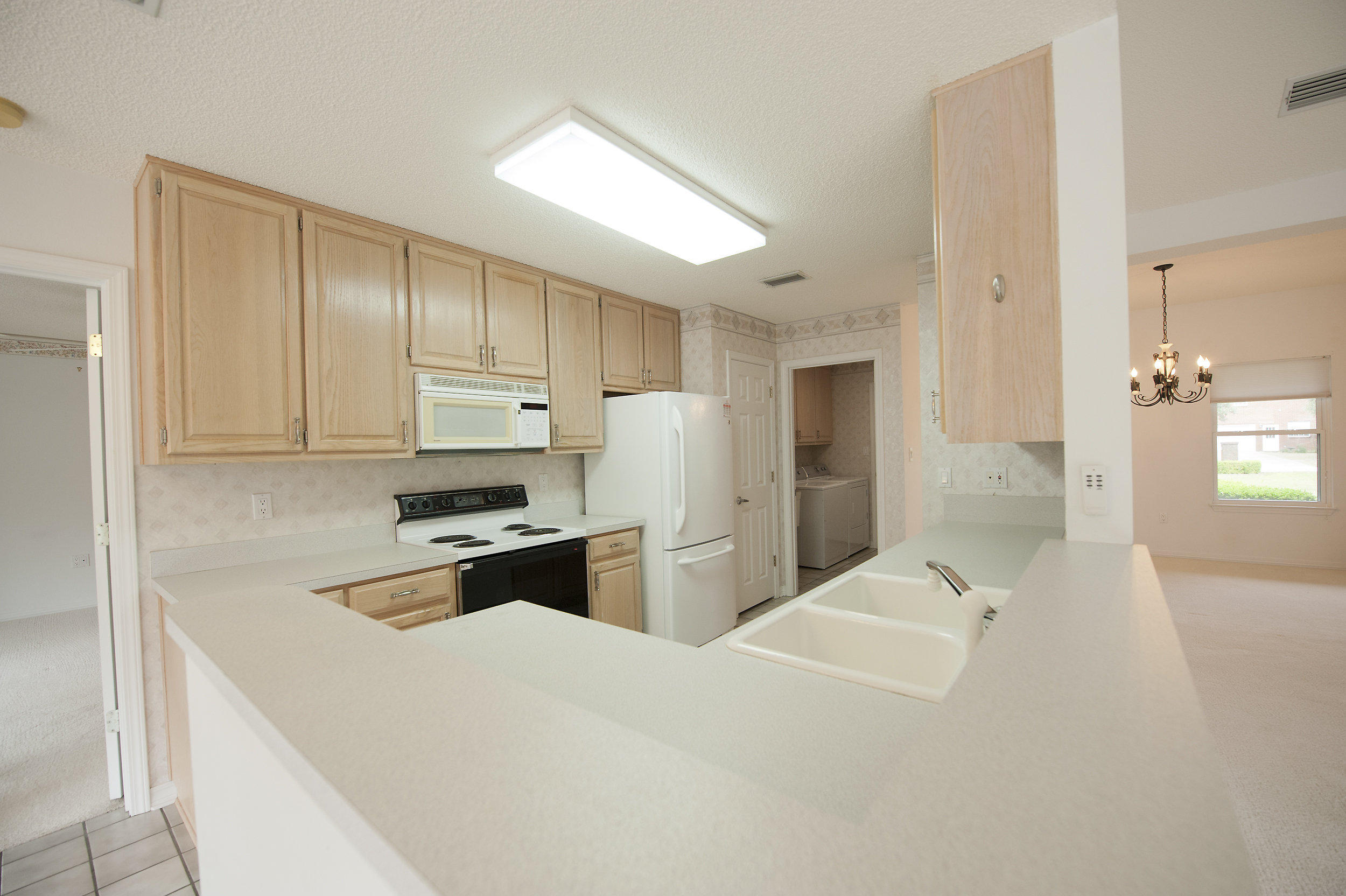 2557 Crescent Road Navarre, FL 32566 - Photo 33 of 48 a kitchen with a refrigerator a stove top oven a sink and cabinets