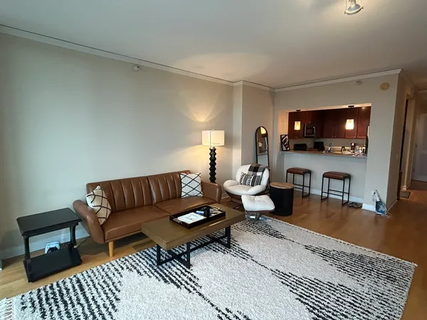a living room with furniture a flat screen tv and a table