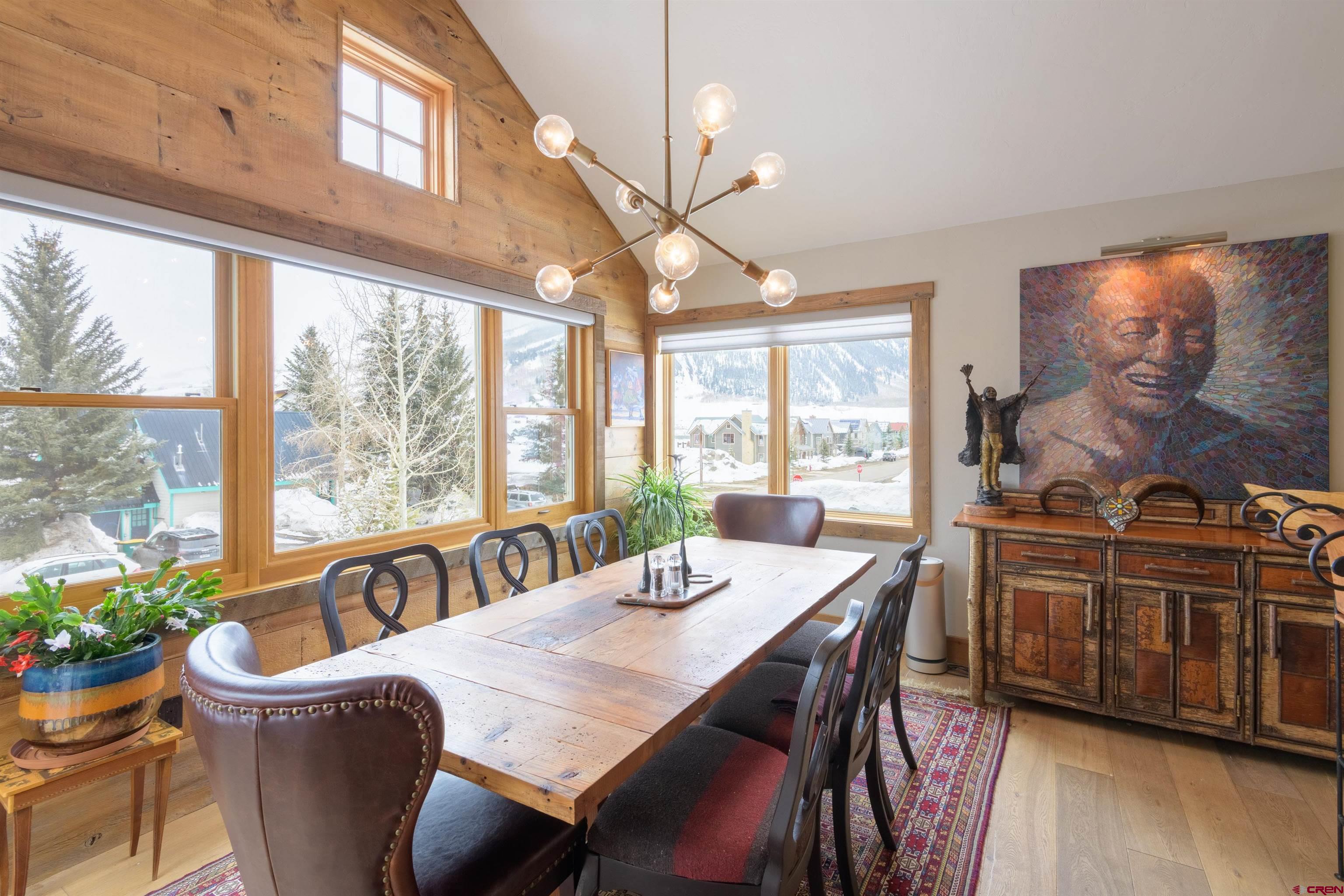 722 Elk Avenue Crested Butte, CO 81224 - Photo 11 of 32 a view of a dining room with furniture a chandelier and wooden floor