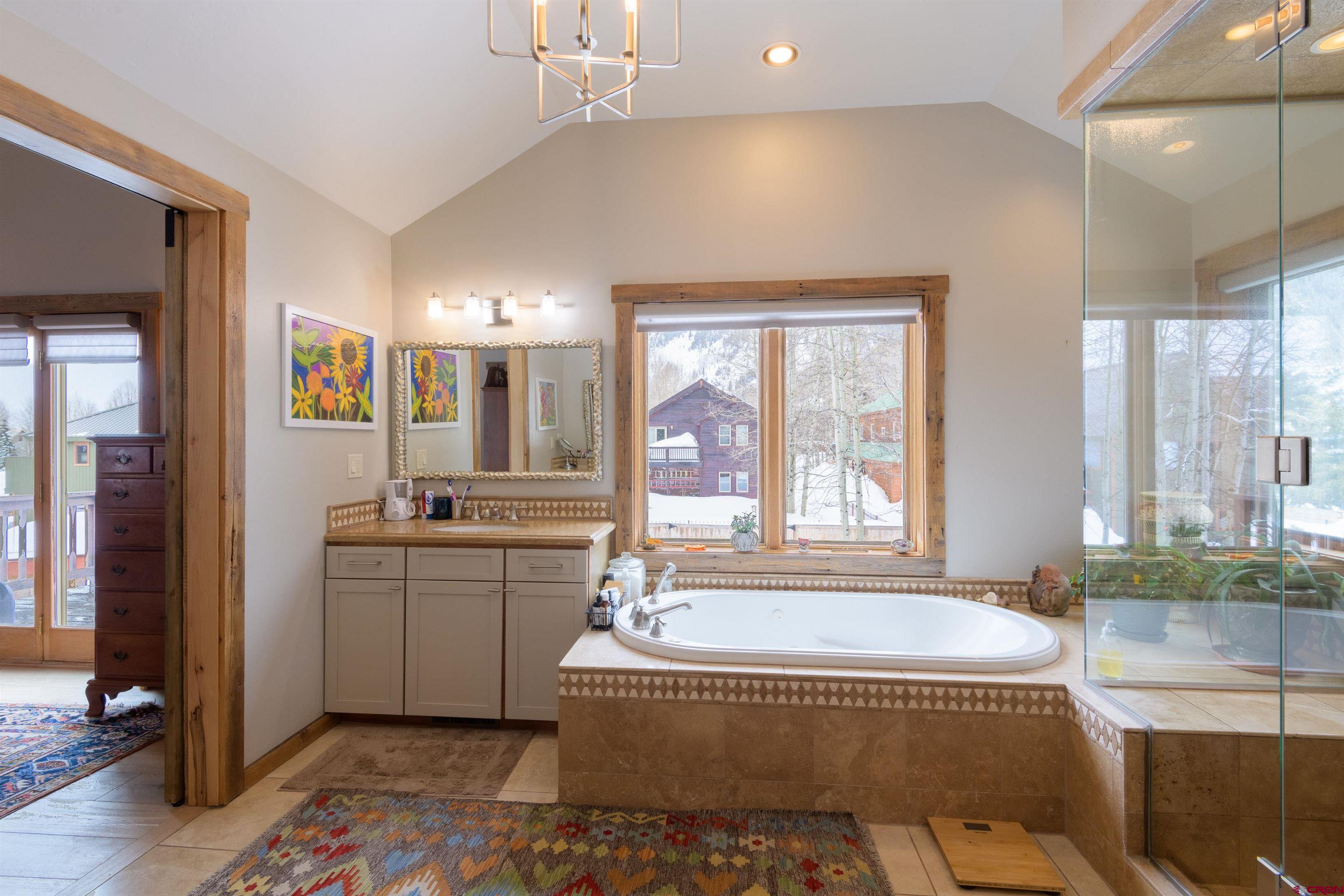 722 Elk Avenue Crested Butte, CO 81224 - Photo 17 of 32 a spacious bathroom with a tub sink and mirror