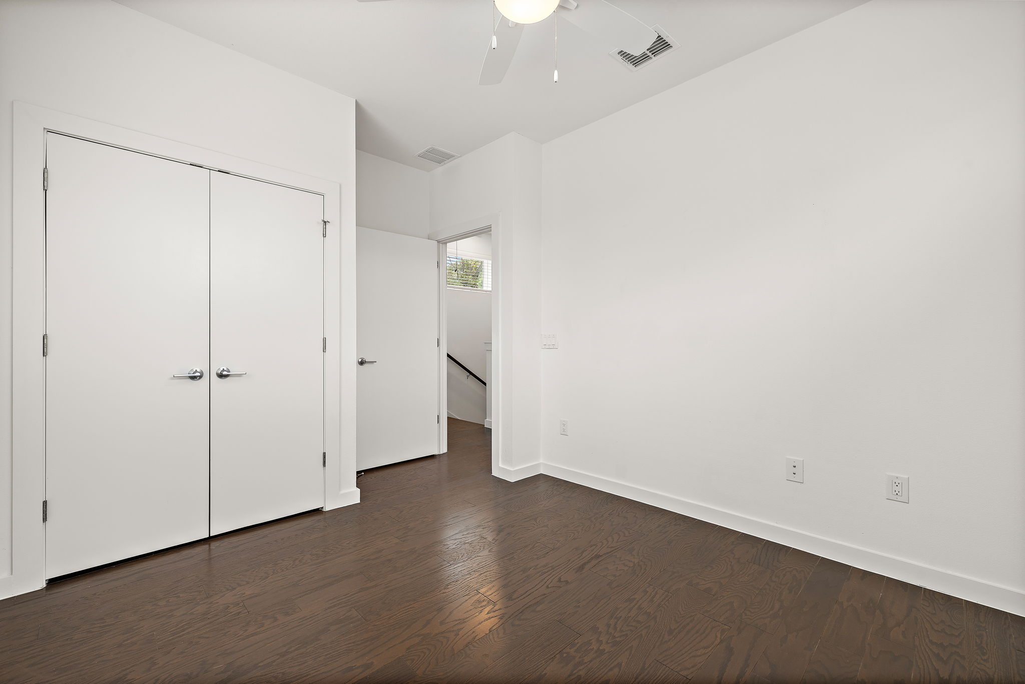 1206 Sarabeth Way Austin, TX 78721 - Photo 19 of 27 Unfurnished bedroom featuring dark wood-type flooring, visible vents, a ceiling fan, and baseboards