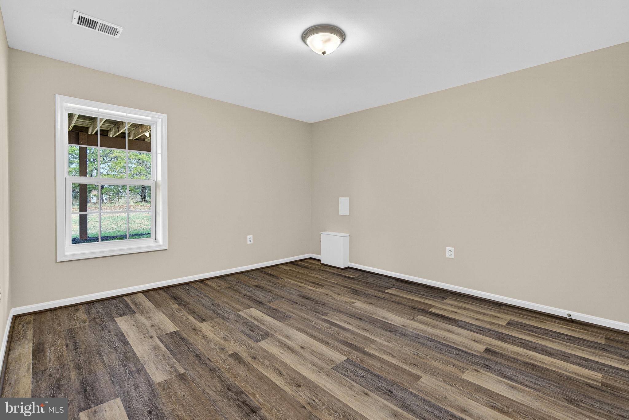 742 Blossom Tree Road Culpeper, VA 22701 - Photo 49 of 60 a view of an empty room with wooden floor and a window