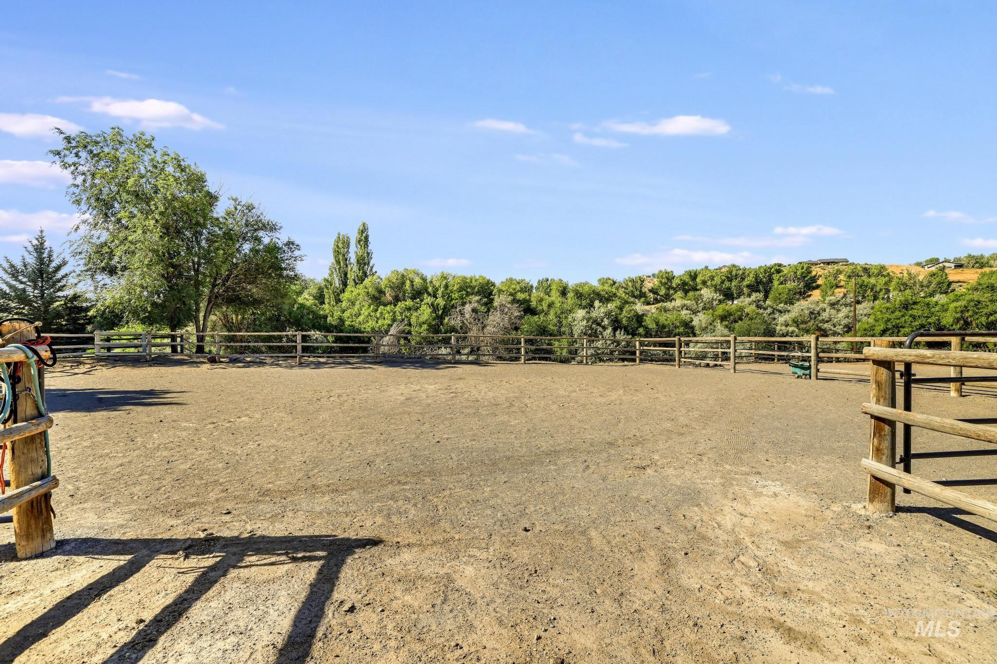 1301 Kanaka Rapids Road Buhl, ID 83316 - Photo 45 of 50 Spacious riding arena featuring a natural wood perimeter fence, earth surface, and mature tree-lined surroundings