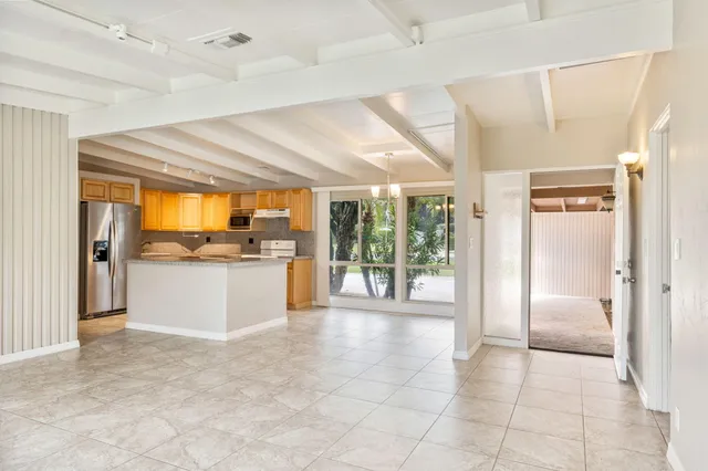 a view of a electric appliances in kitchen and an empty room