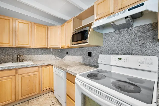 a kitchen with a sink a stove and cabinets