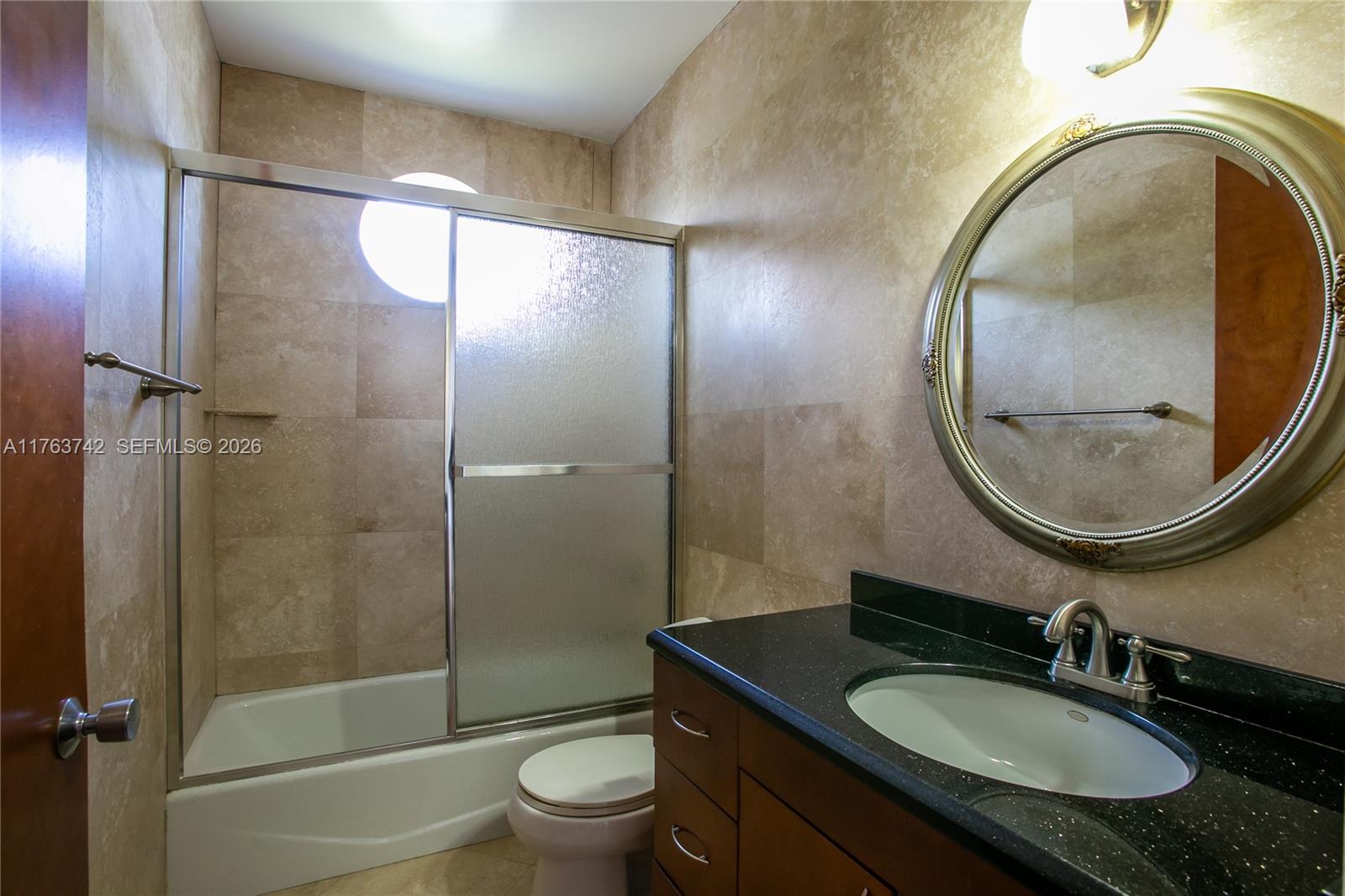 4750 Southwest 43rd Avenue Dania Beach, FL 33314 - Photo 23 of 28 a bathroom with a granite countertop sink toilet mirror and shower