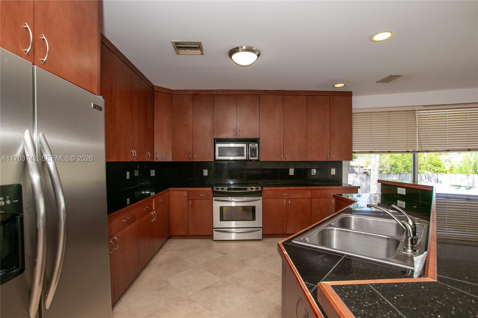 4750 Southwest 43rd Avenue Dania Beach, FL 33314 - Photo 9 of 28 a kitchen with stainless steel appliances granite countertop a sink stove and refrigerator