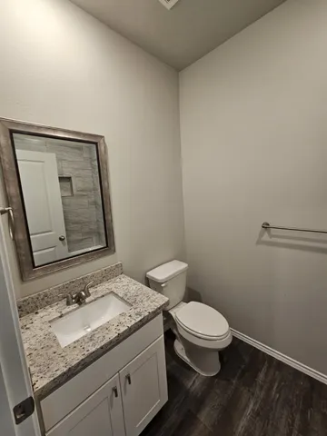 a bathroom with a granite countertop toilet and sink