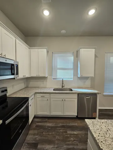 a kitchen with stainless steel appliances granite countertop a sink stove and cabinets