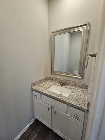 a bathroom with a granite countertop sink and a mirror