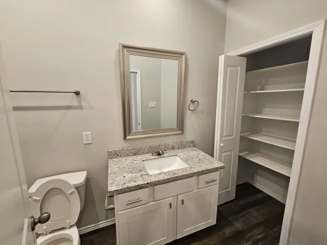 a bathroom with a granite countertop sink a mirror and a vanity