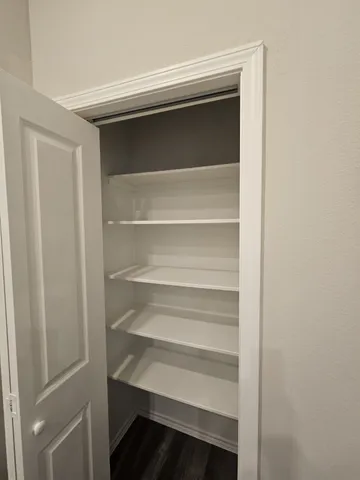 a view of walk in closet with empty racks