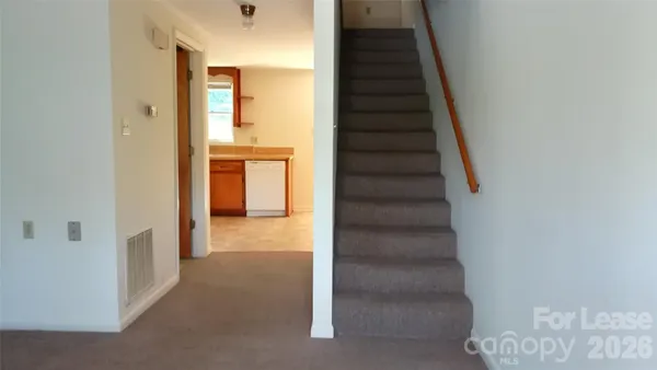 a view of a hallway with wooden cabinets and staircase