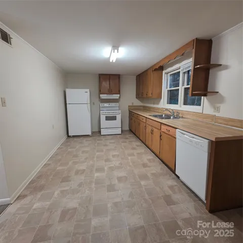 a large white kitchen with cabinets