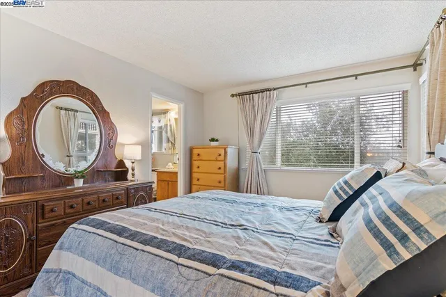 a bedroom with a bed a mirror and a large window