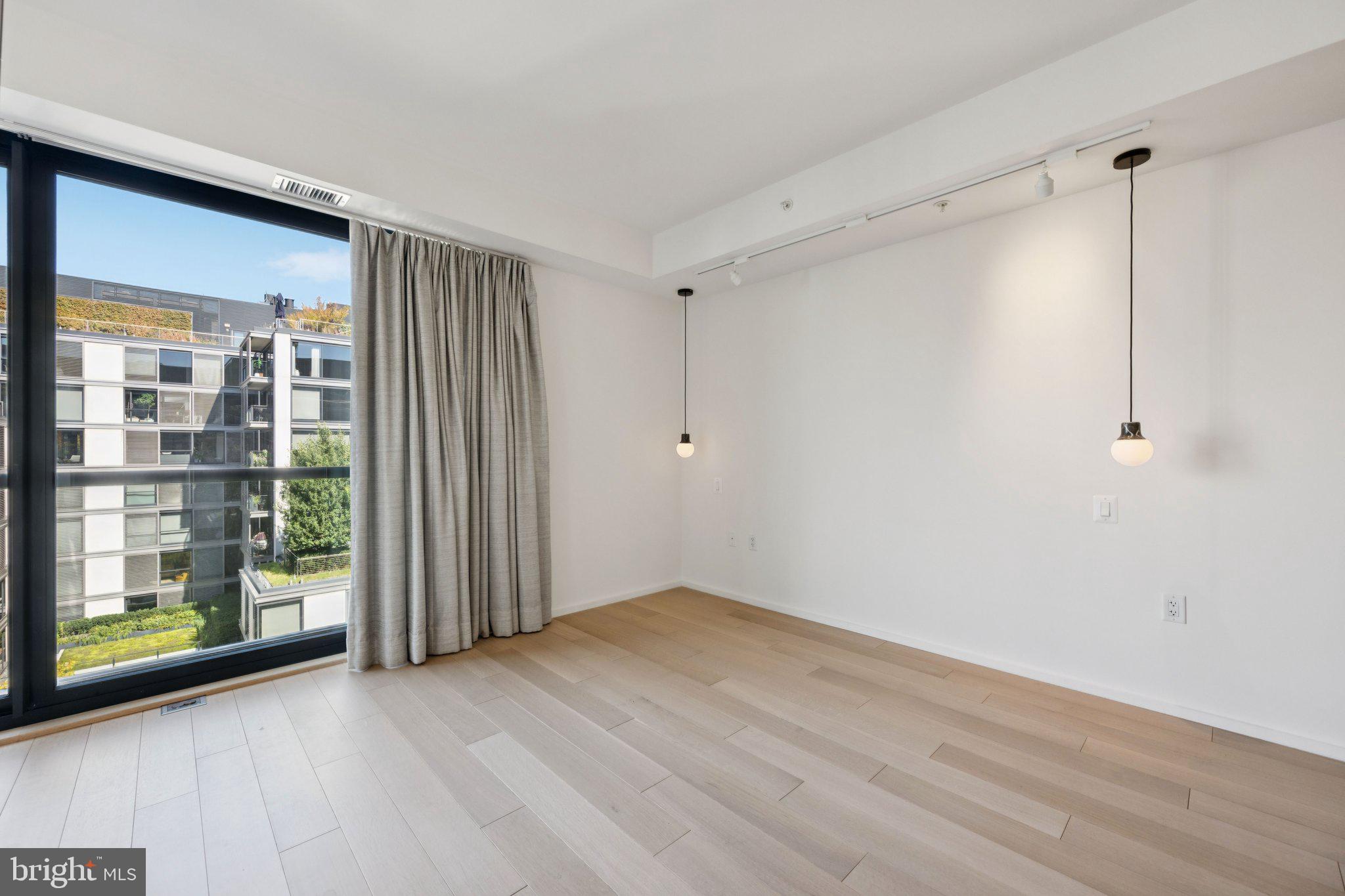 925 H Street Northwest, Unit 903 Washington, DC 20001 - Photo 14 of 36 a view of an empty room with wooden floor and a window