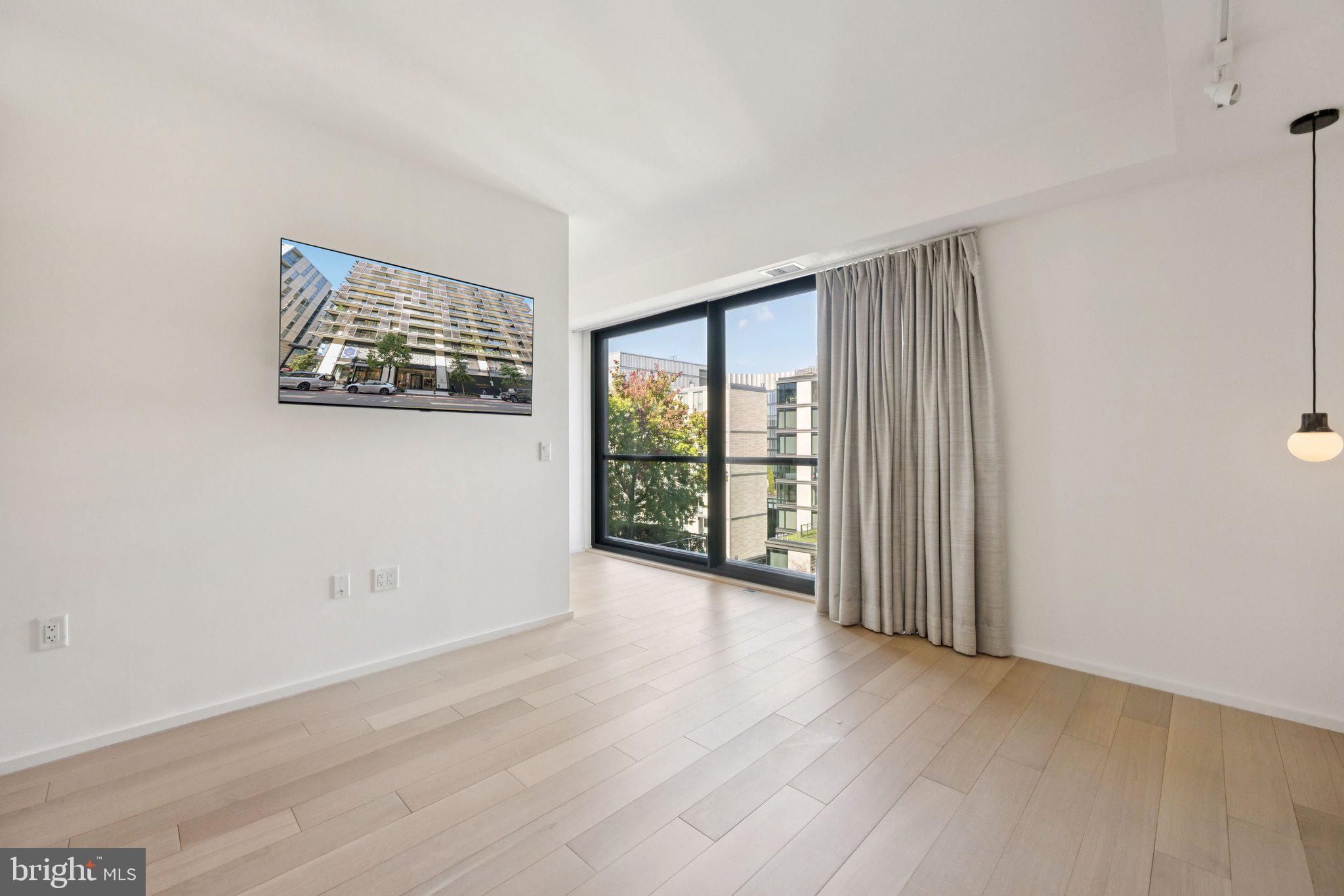 925 H Street Northwest, Unit 903 Washington, DC 20001 - Photo 15 of 36 an empty room with wooden floor and windows