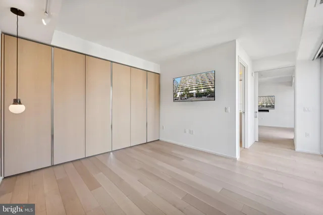 a view of an empty room with closet and a window