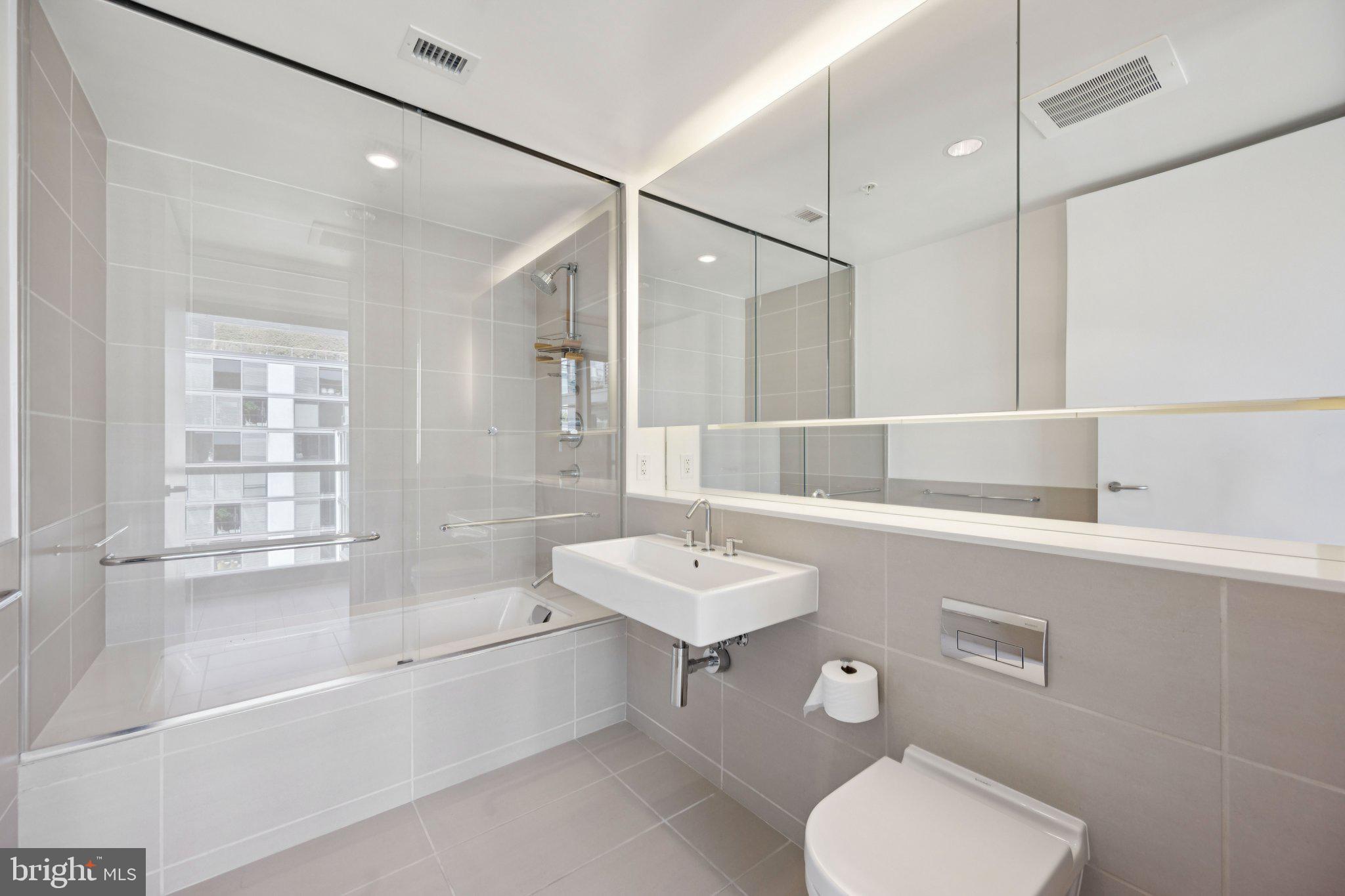 925 H Street Northwest, Unit 903 Washington, DC 20001 - Photo 19 of 36 a bathroom with a sink toilet and shower