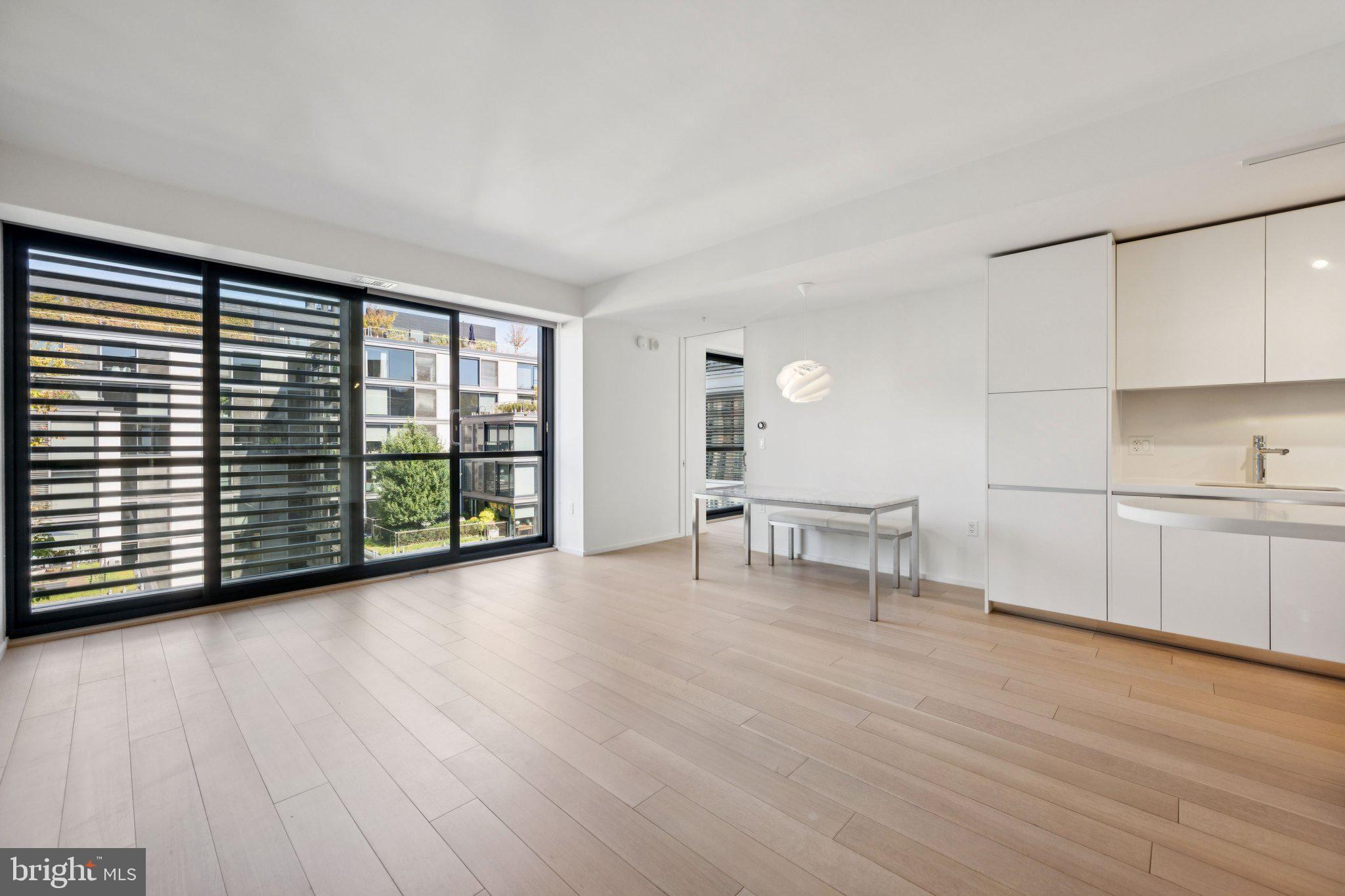 925 H Street Northwest, Unit 903 Washington, DC 20001 - Photo 2 of 36 a view of an empty room with a window and wooden floor