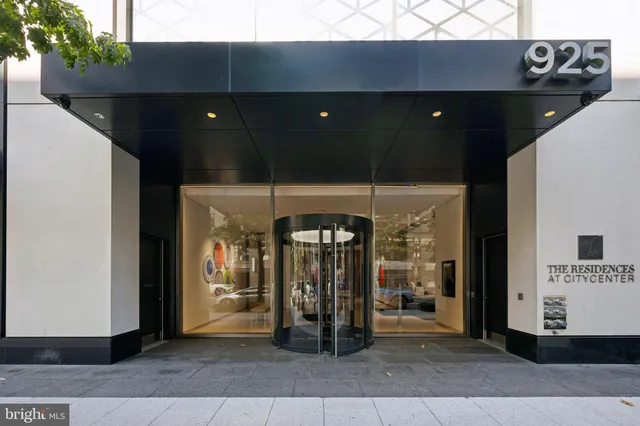 a white cabinet with a black white bedspread and pillows