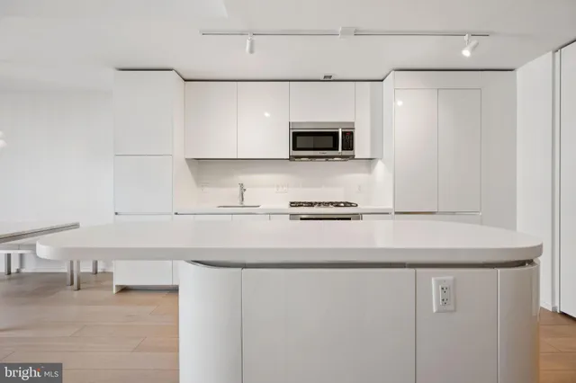a kitchen with stainless steel appliances a sink a stove a microwave and cabinets