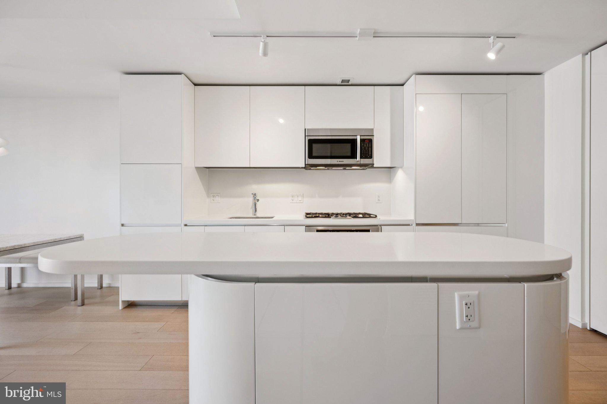 925 H Street Northwest, Unit 903 Washington, DC 20001 - Photo 8 of 36 a kitchen with stainless steel appliances a sink a stove a microwave and cabinets