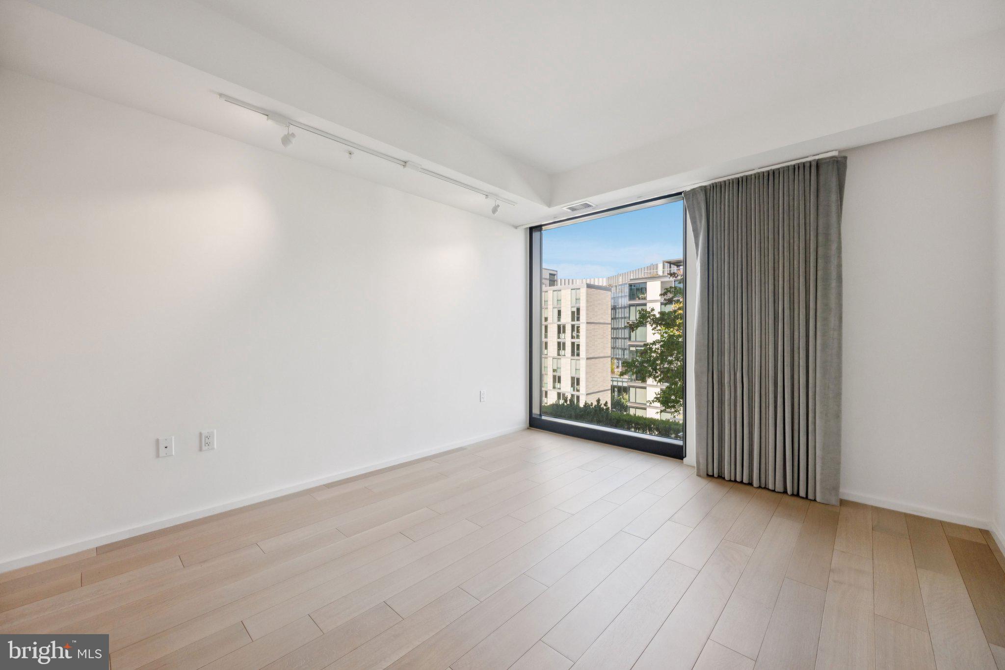 925 H Street Northwest, Unit 903 Washington, DC 20001 - Photo 10 of 36 a view of an empty room with wooden floor and a window