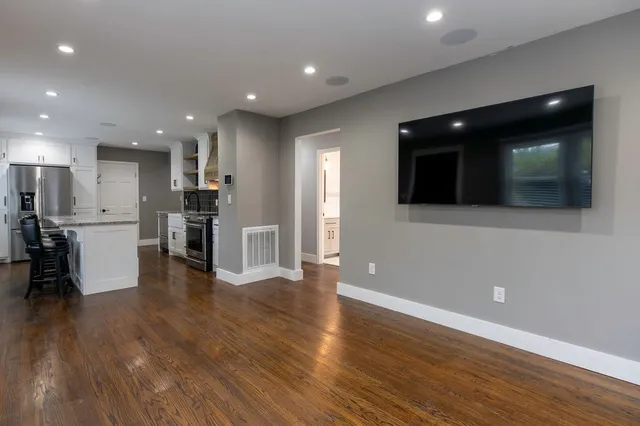 a view of kitchen with stainless steel appliances kitchen island wooden floor and window