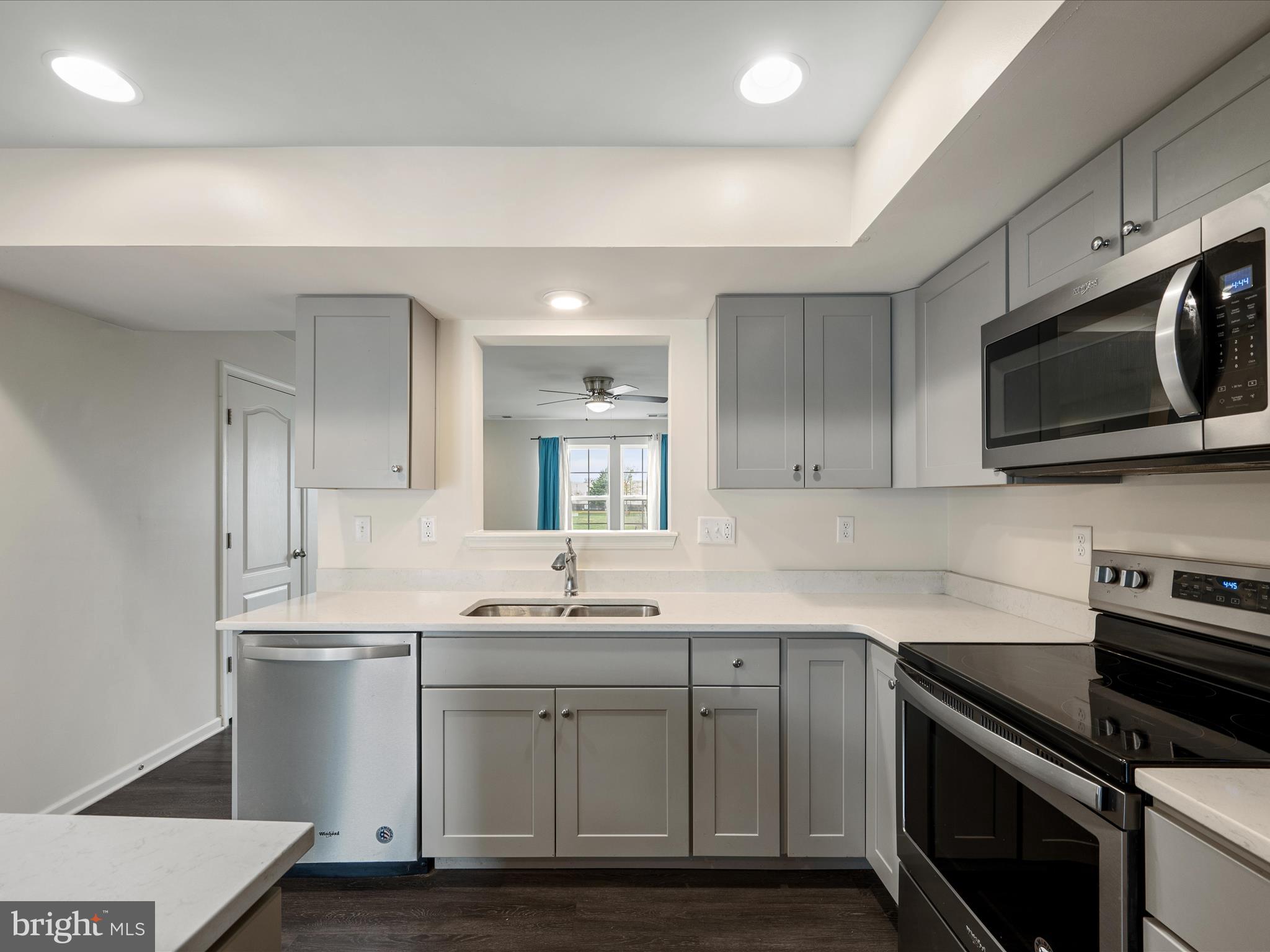 640 Thumper Drive Ranson, WV 25438 - Photo 14 of 50 a kitchen with stainless steel appliances granite countertop a sink a stove a microwave and wooden cabinets