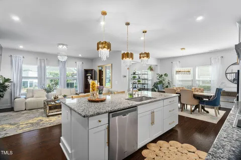 a kitchen with stainless steel appliances kitchen island granite countertop a stove a sink and a refrigerator