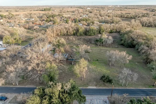 an aerial view of residential houses with outdoor space and trees
