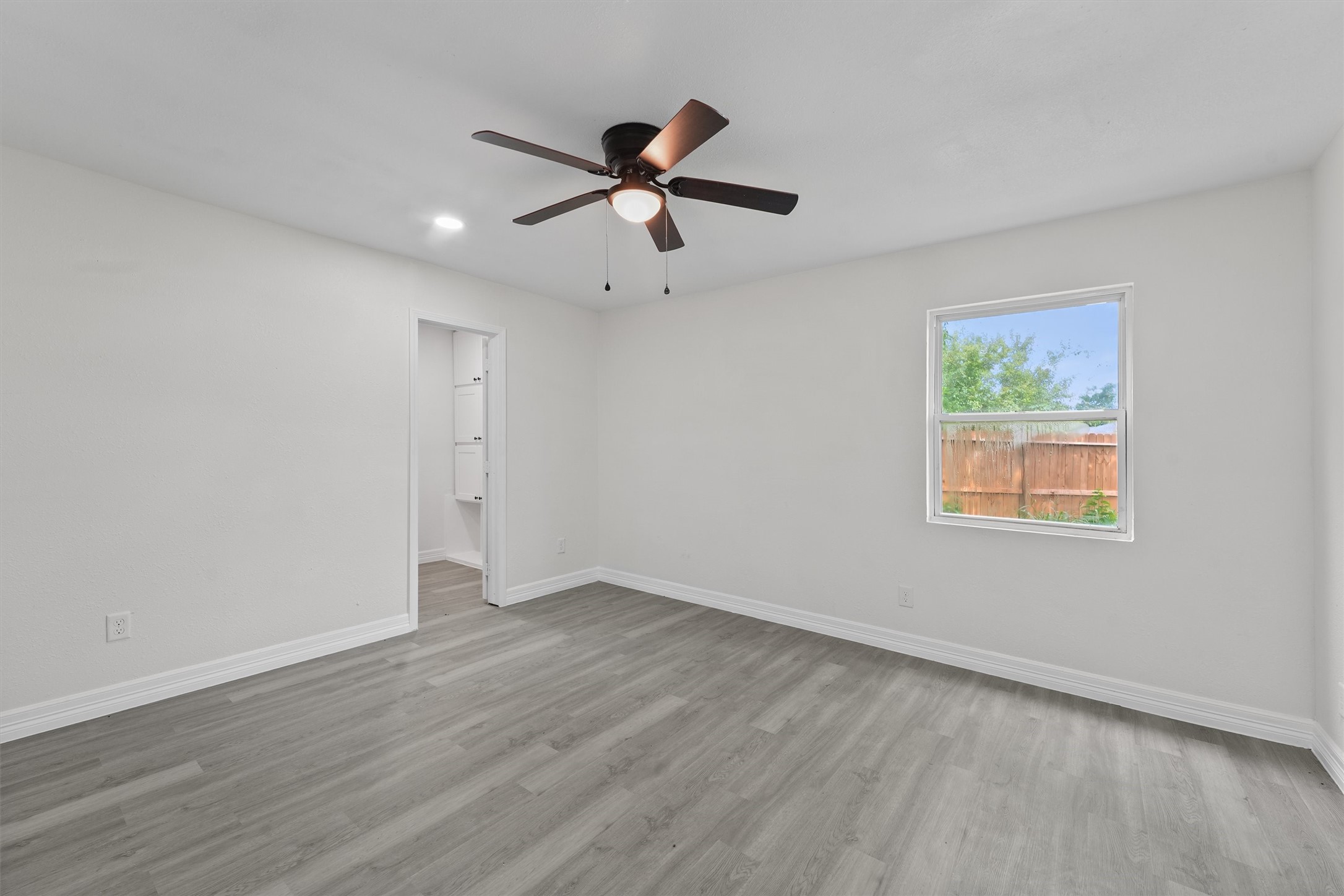 1615 Hiller Street Houston, TX 77015 - Photo 15 of 26 an empty room with wooden floor ceiling fan and windows