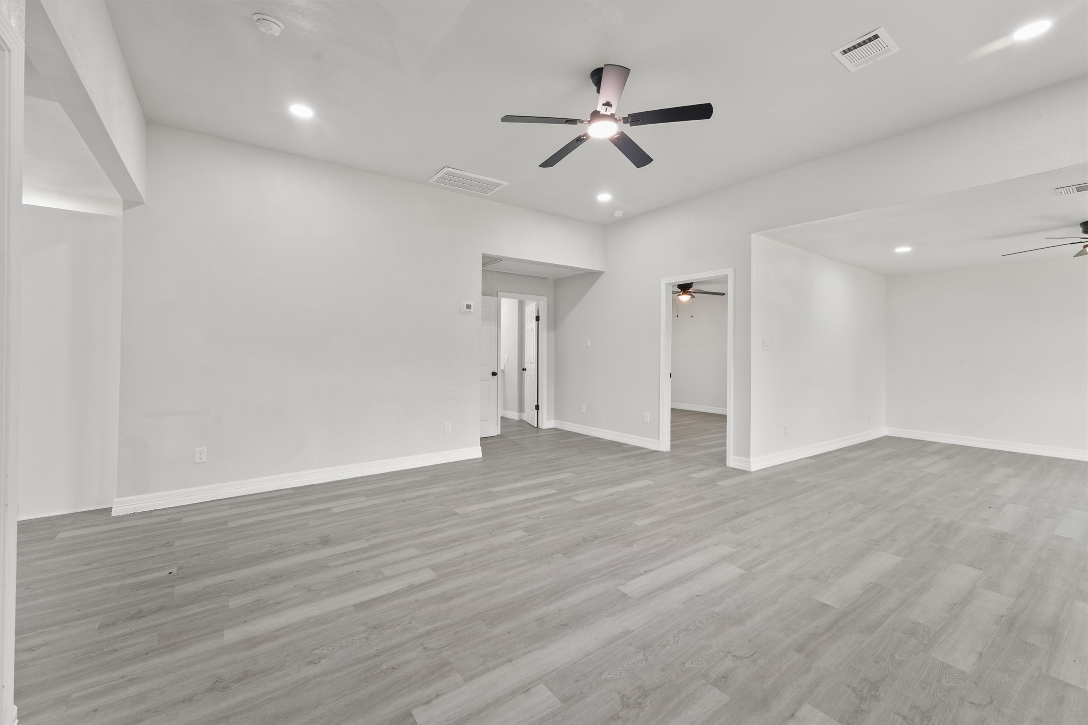 1615 Hiller Street Houston, TX 77015 - Photo 7 of 26 a view of an empty room with wooden floor and a ceiling fan