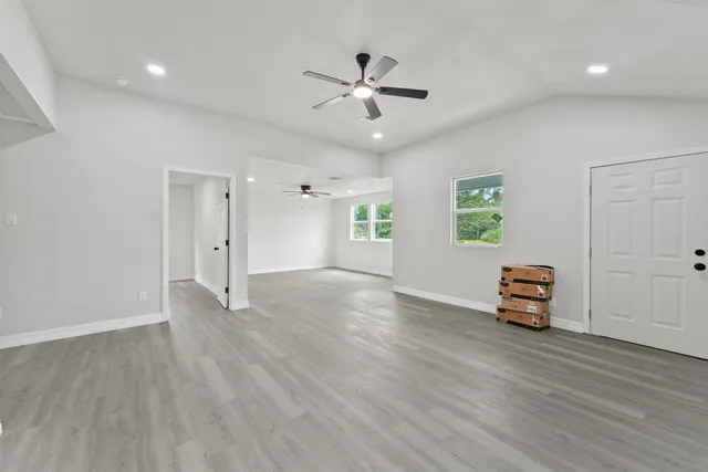 an empty room with window and wooden floor