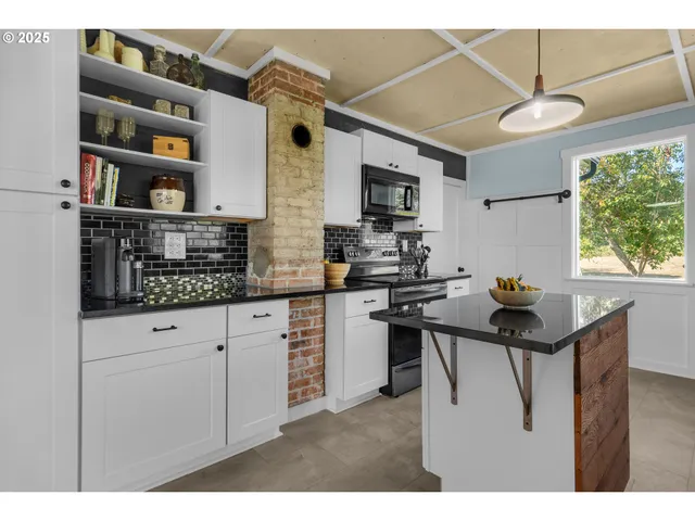 a kitchen with stainless steel appliances kitchen island granite countertop a sink and cabinets