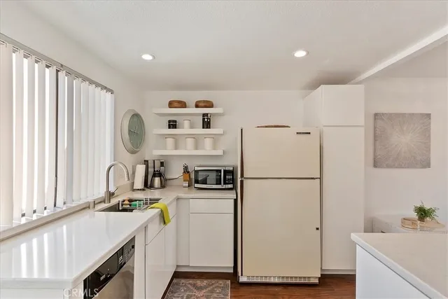 a kitchen with a refrigerator a sink and a stove top oven