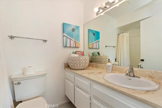 a bathroom with a granite countertop sink a toilet and mirror