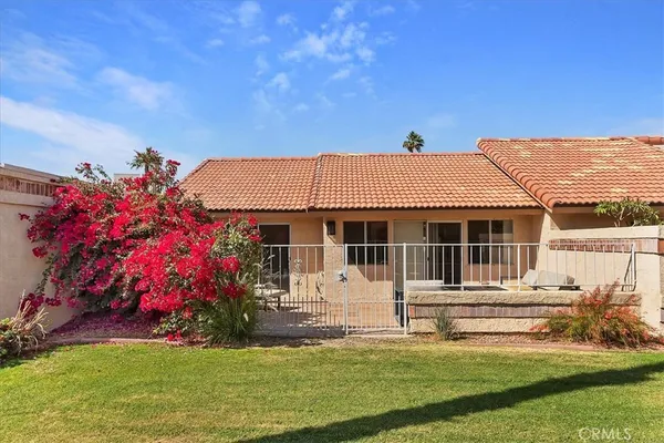a front view of a house with a garden and yard