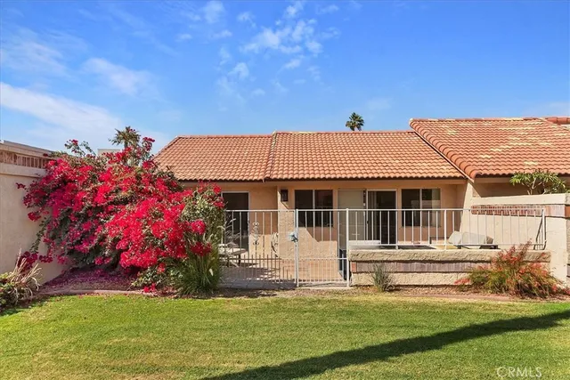 a front view of a house with a garden and yard