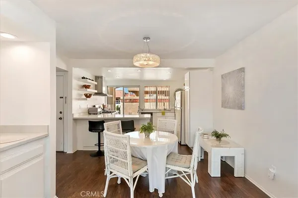 a view of a dining room with furniture a chandelier and wooden floor