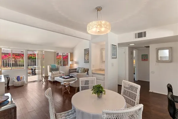 a living room with furniture kitchen and a chandelier