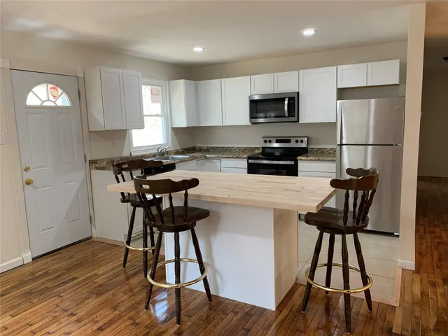 a kitchen with a table chairs refrigerator and microwave
