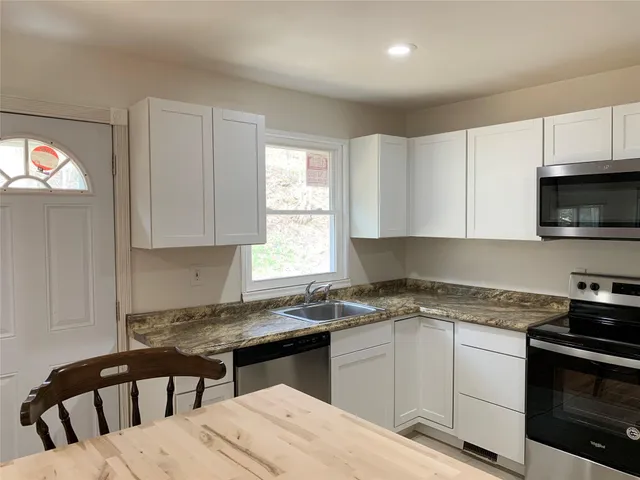 a kitchen with a stove a sink and a microwave