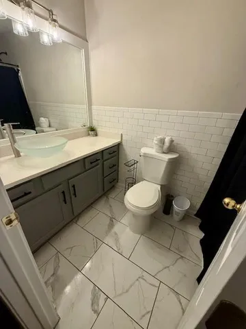 a bathroom with a sink mirror vanity and toilet